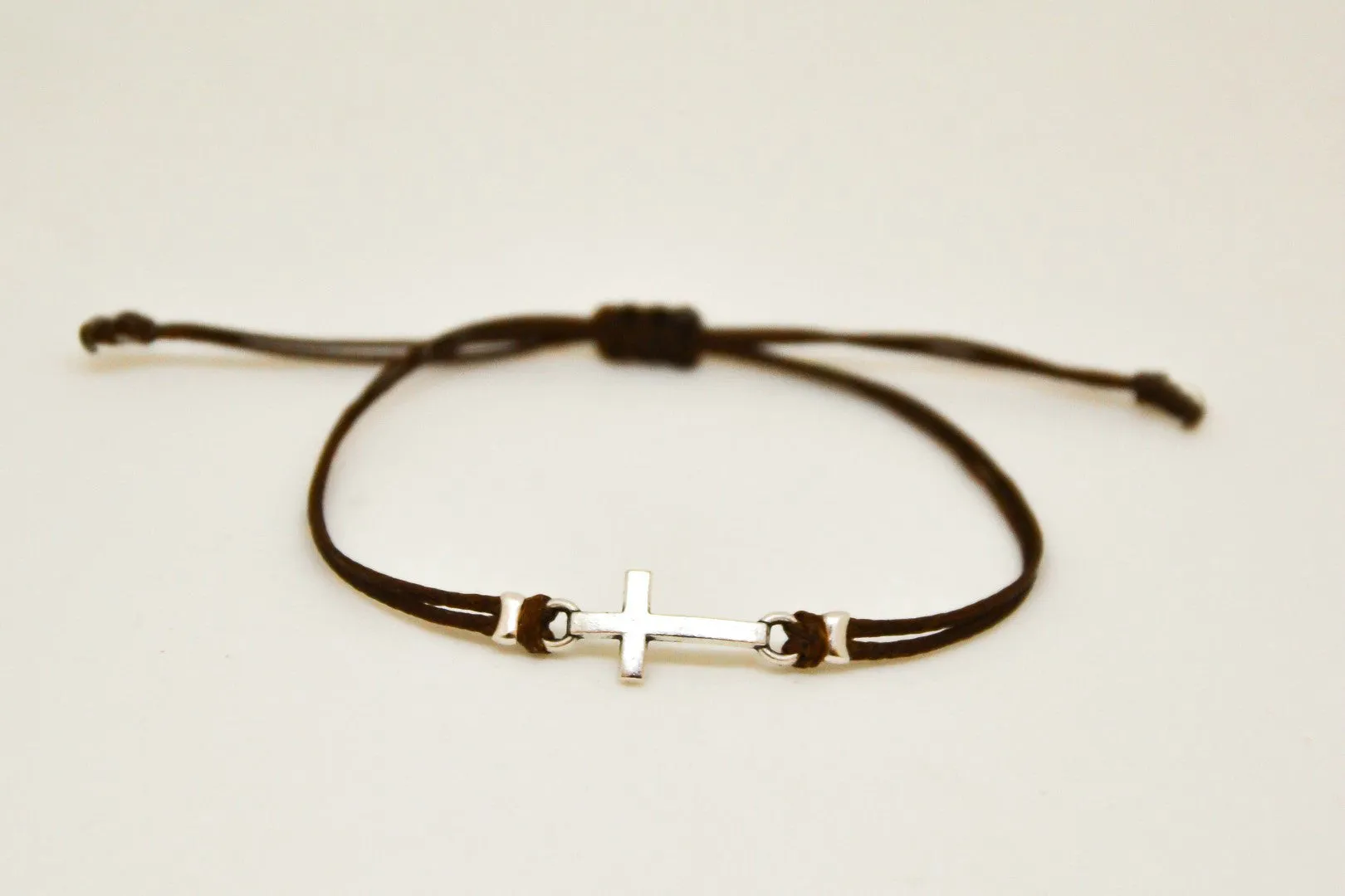 Women bracelet with silver cross charm, brown cord