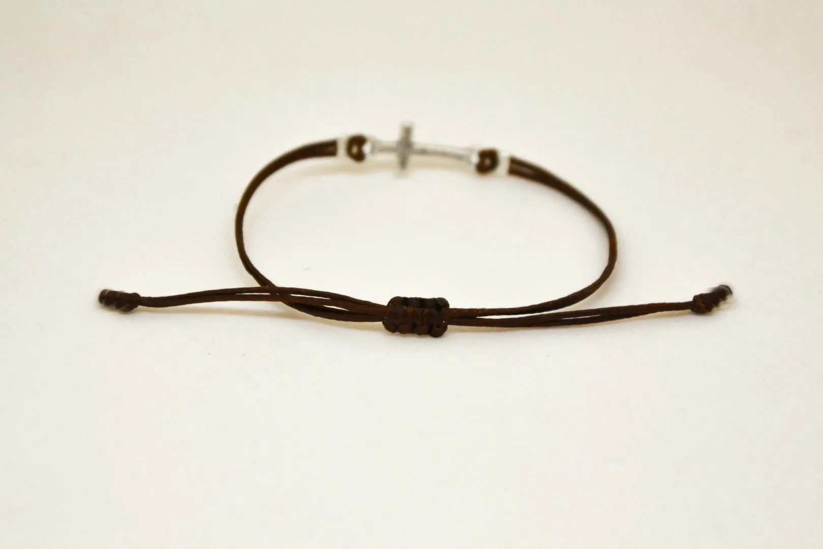 Women bracelet with silver cross charm, brown cord